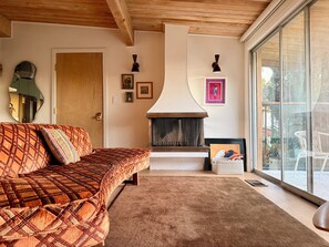 A cozy living room with a sofa, fireplace, and large windows. - Spacious Hillside Mid-century Designer Home with Views (Glendale)