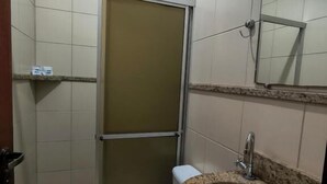 A bathroom with a toilet, sink, and shower. - Hotel do Porto (Porto Velho)