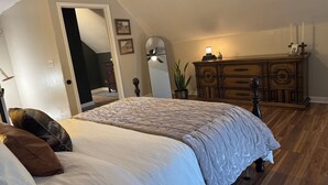 Ein Schlafzimmer mit Bett, Schminktisch und Blumentopf.