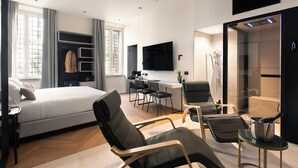 A modern hotel room with a bed, seating area, kitchenette, and a large window. - At Forty-One Apt 02 (Rome)