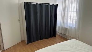 A bedroom with a bed, a door, and a curtain. - 5 minutes from the train station! Bright and spacious apartment (Romilly-sur-Seine)