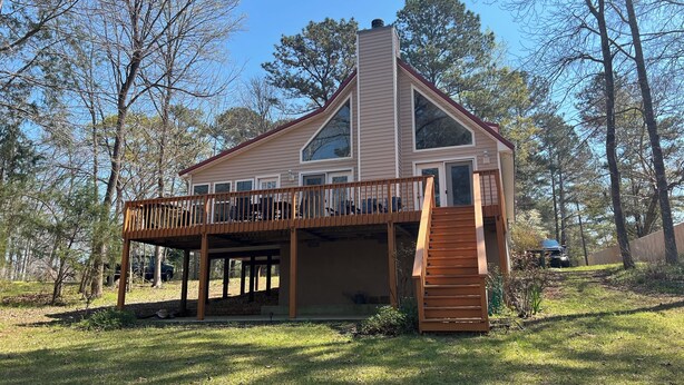 A two-story house with a balcony, a chimney, and a deck. - Lake Front Home with Fireplace Private Boat Dock & Kayaks (Milledgeville)