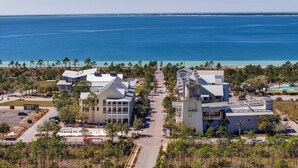 Ein Küstenhotel mit einer zentralen Promenade, Blick auf den Strand und einem Poolbereich.