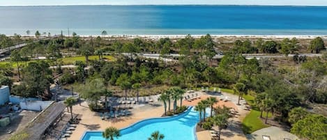 A resort with a swimming pool, beach access, and a view of the ocean.