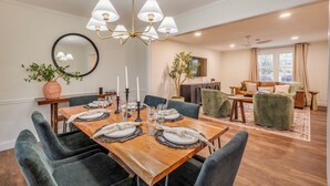 Un coin repas avec une table en bois dressée pour six personnes, entourée de chaises rembourrées.