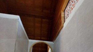 A bathroom with a wooden vanity, a round mirror, a bowl sink, and a shower. - les chalets pecatu (Pecatu)