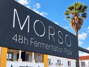 Un edificio con un letrero que dice 'MORSO 48h Fermentation Pizza'.