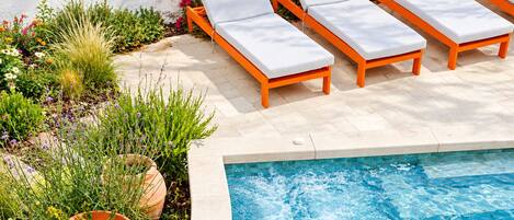 A poolside area with lounge chairs and a swimming pool.