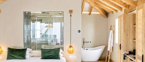 A modern bedroom with a large bed, a bathtub, and a wooden ceiling.