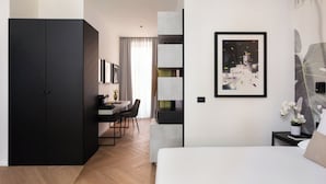 Ein modernes Hotelzimmer mit Bett, Schreibtisch, Stuhl und Kleiderschrank.