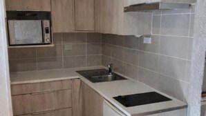 A compact kitchen with a microwave, sink, and built-in stove.