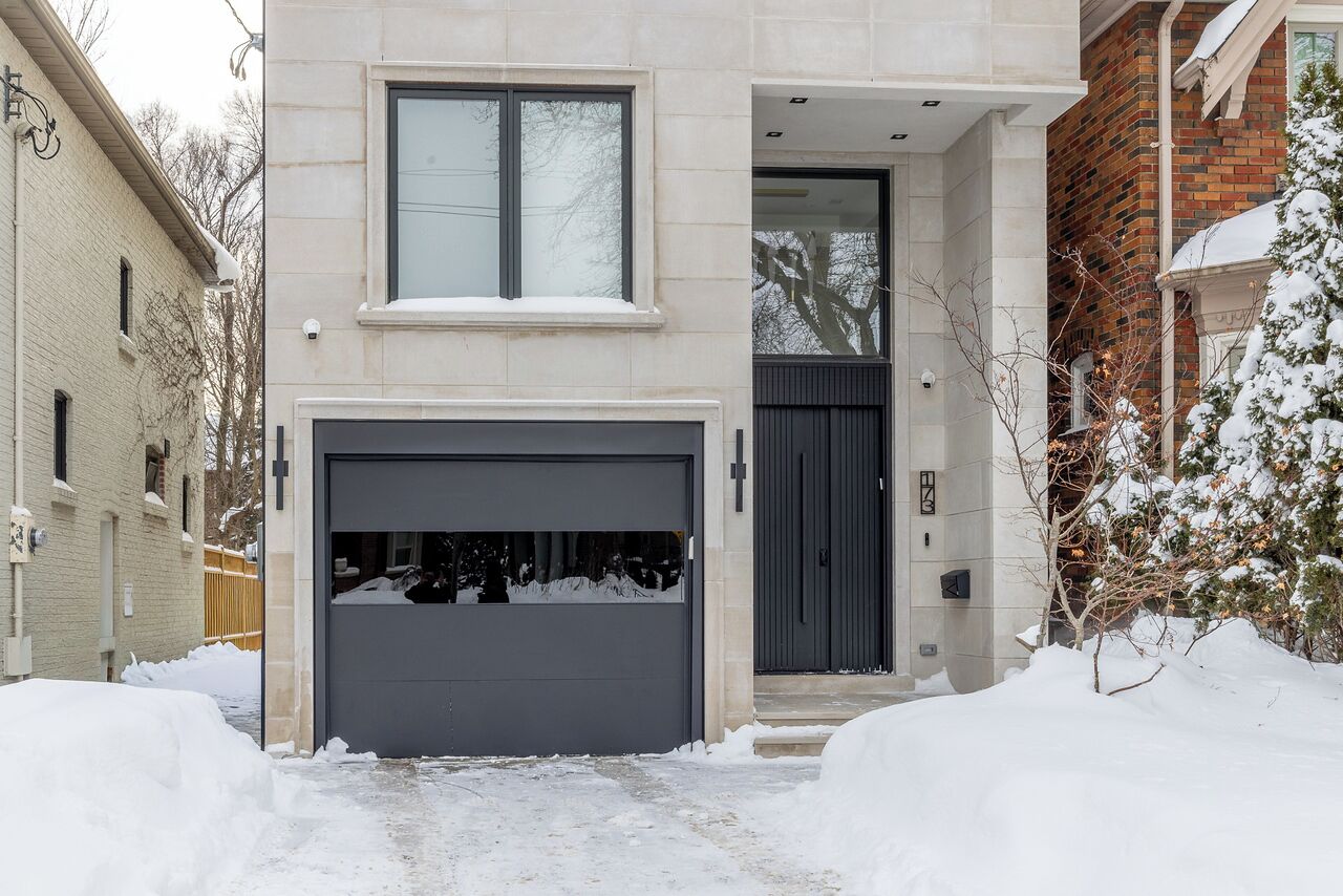 A two-story house with a garage, a front door, and a small porch.