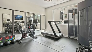 Ett gym med löpband, motionscykel och vikter.