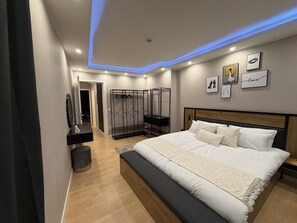 Une chambre à coucher moderne avec un grand lit, un dressing et une salle de bain avec un miroir.