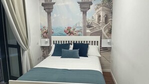 Une chambre à coucher avec un lit, une table de chevet, une fresque murale et une fenêtre avec des rideaux.