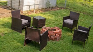 An outdoor seating area with wicker chairs and a small table, surrounded by a pile of bricks. - Cozy 1-bedroom apartment in tranquil Huntington with AC (Huntington)