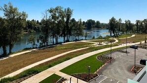 Un espace de stationnement offrant une vue sur la rivière, un sentier sinueux et une zone herbeuse.
