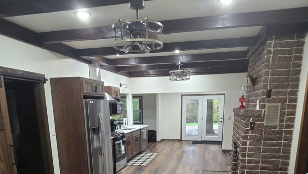 Una cocina amplia con electrodomésticos modernos, un comedor con una silla blanca y una pared de acento de piedra.