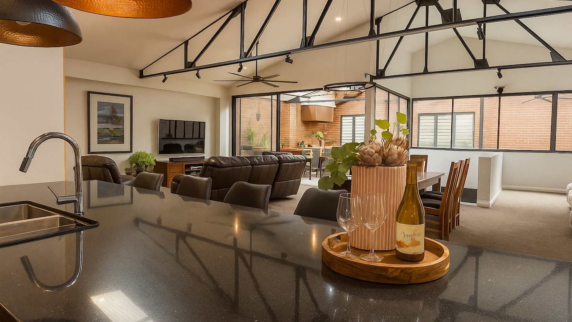 A spacious living area with a kitchen island, seating, and a dining area.