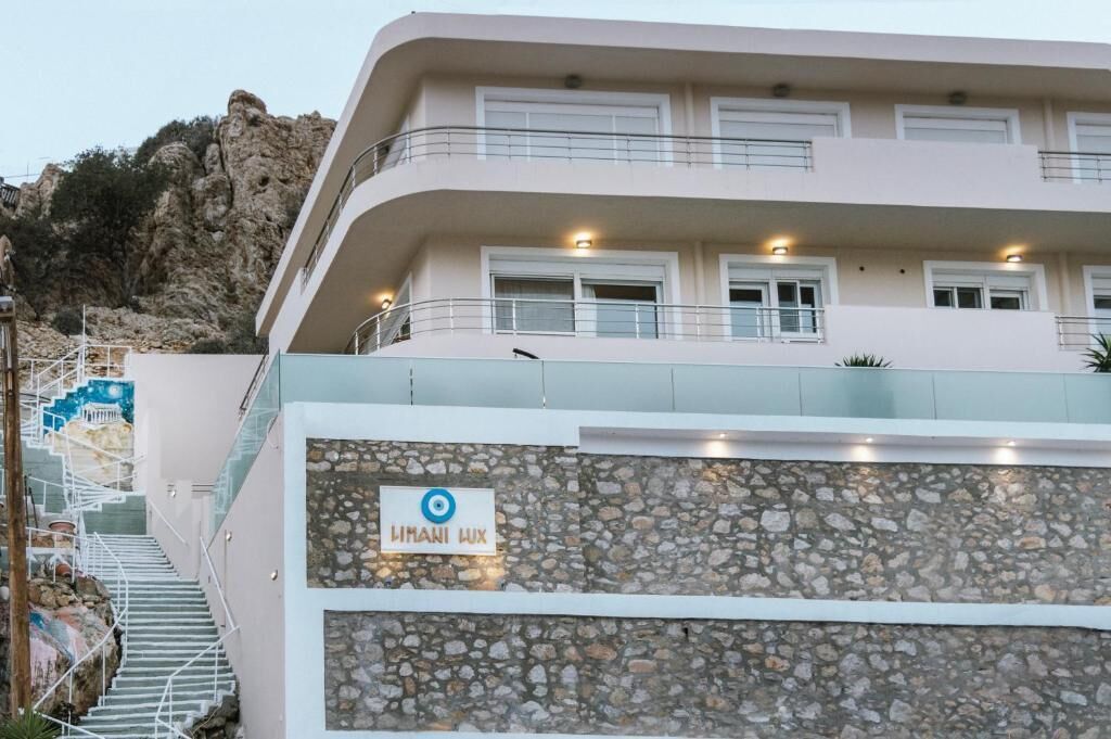 A multi-story building with a stone facade, a sign reading 'HIMANI LUX,' and a staircase leading to an upper level.