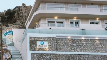 A multi-story building with a stone facade, a sign reading 'HIMANI LUX,' and a staircase leading to an upper level.
