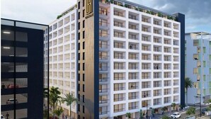 A multi-story hotel with a grid of windows, a prominent logo on the facade, and a flat roof with greenery. - Brand New Executive Suite - Close to Airport, Swimming Pool, Gym (Gibraltar)