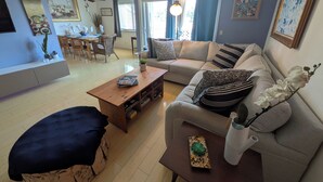 Un salon comprenant un canapé, une table basse et un coin repas avec des chaises et une table.