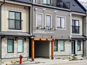 A multi-story building with a stone facade, large windows, and a sign indicating it is a visitor accommodation at 810 10th St.