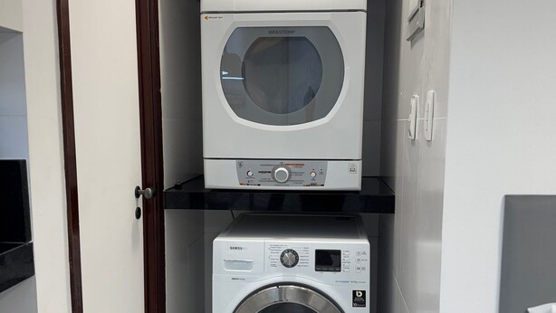 Une buanderie équipée d’un lave-linge à chargement par le haut et d’un sèche-linge à chargement frontal.