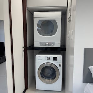 A laundry room with a top-loading washer and a front-loading dryer.