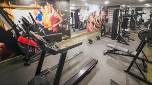 A gym with treadmills, weight machines, and a mirrored wall. - Flat com piscina a 50m da praia (Recife)