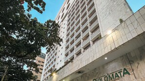 A building with a 'Diplomata' sign, featuring a modern architectural design with a prominent facade and multiple balconies.