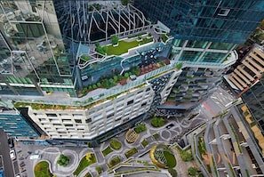 A modern high-rise building with a unique angular design, featuring multiple levels and a rooftop garden. - Level 69 Bay Views & Japanese Soaking Tub (Melbourne)