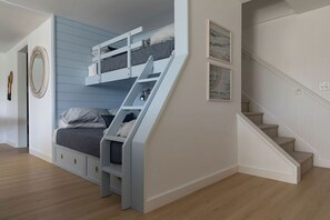 A bedroom with a bunk bed, a staircase, and a wall-mounted circular mirror. - Designer Waterfront Newly Renovated Cottage "ROXABOXEN" (Tremont)