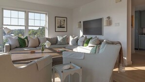Ein Wohnzimmer mit einer Sofagarnitur, einem Couchtisch und einem Fernseher.