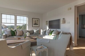 A living room with a sofa set, a coffee table, and a television. - Designer Waterfront Newly Renovated Cottage "ROXABOXEN" (Tremont)