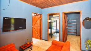 A room with a television, a wooden door, a bench, and a sofa. - 🌋Near La Fortuna : Private villa with private pool surrounded by nature (Provincia de Alajuela)