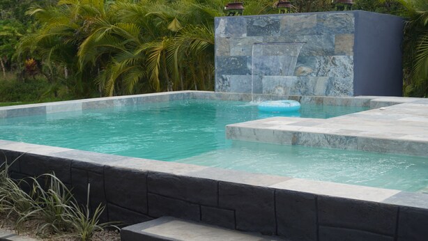 A rectangular swimming pool with a stone border and a small floating platform. - 🌋Near La Fortuna : Private villa with private pool surrounded by nature (Provincia de Alajuela)