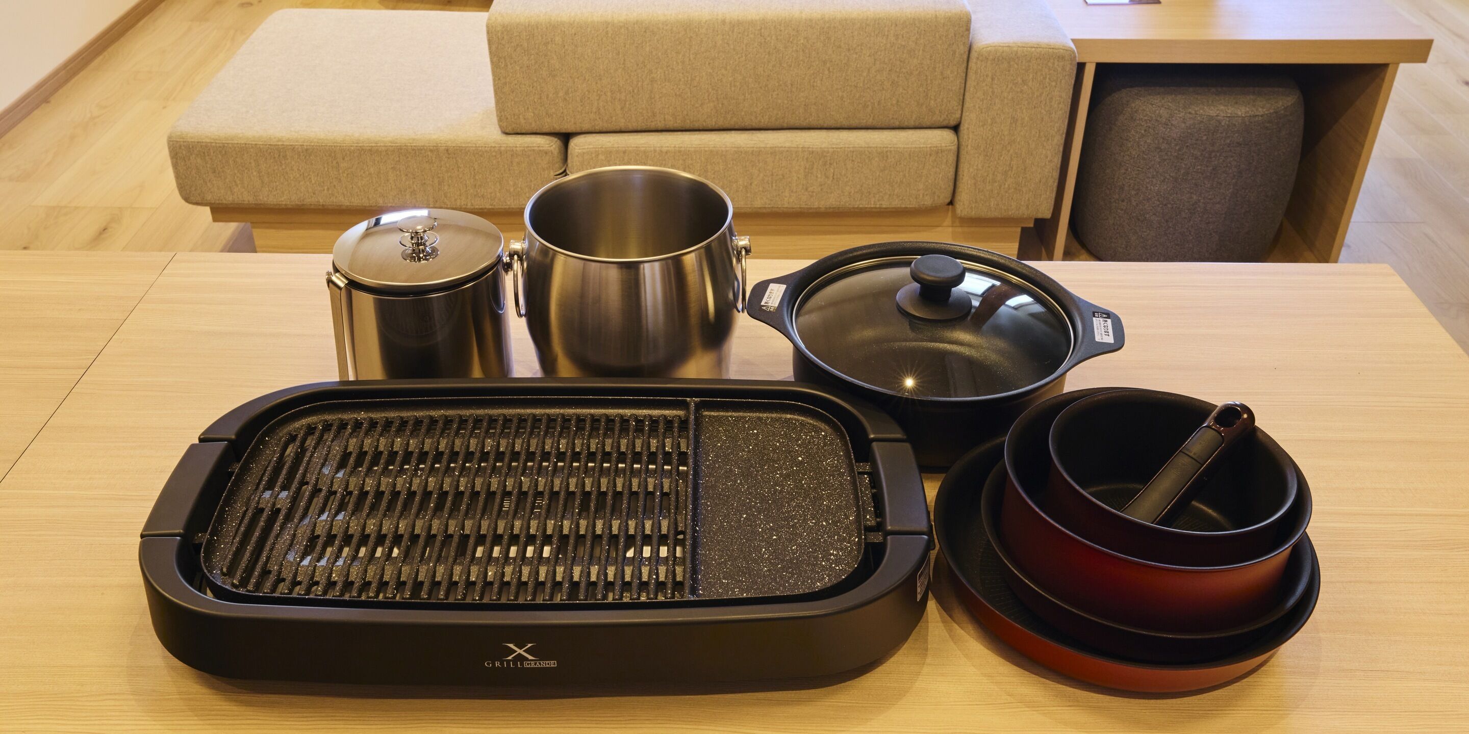 A kitchen area with a grill, pots, and a dining table.