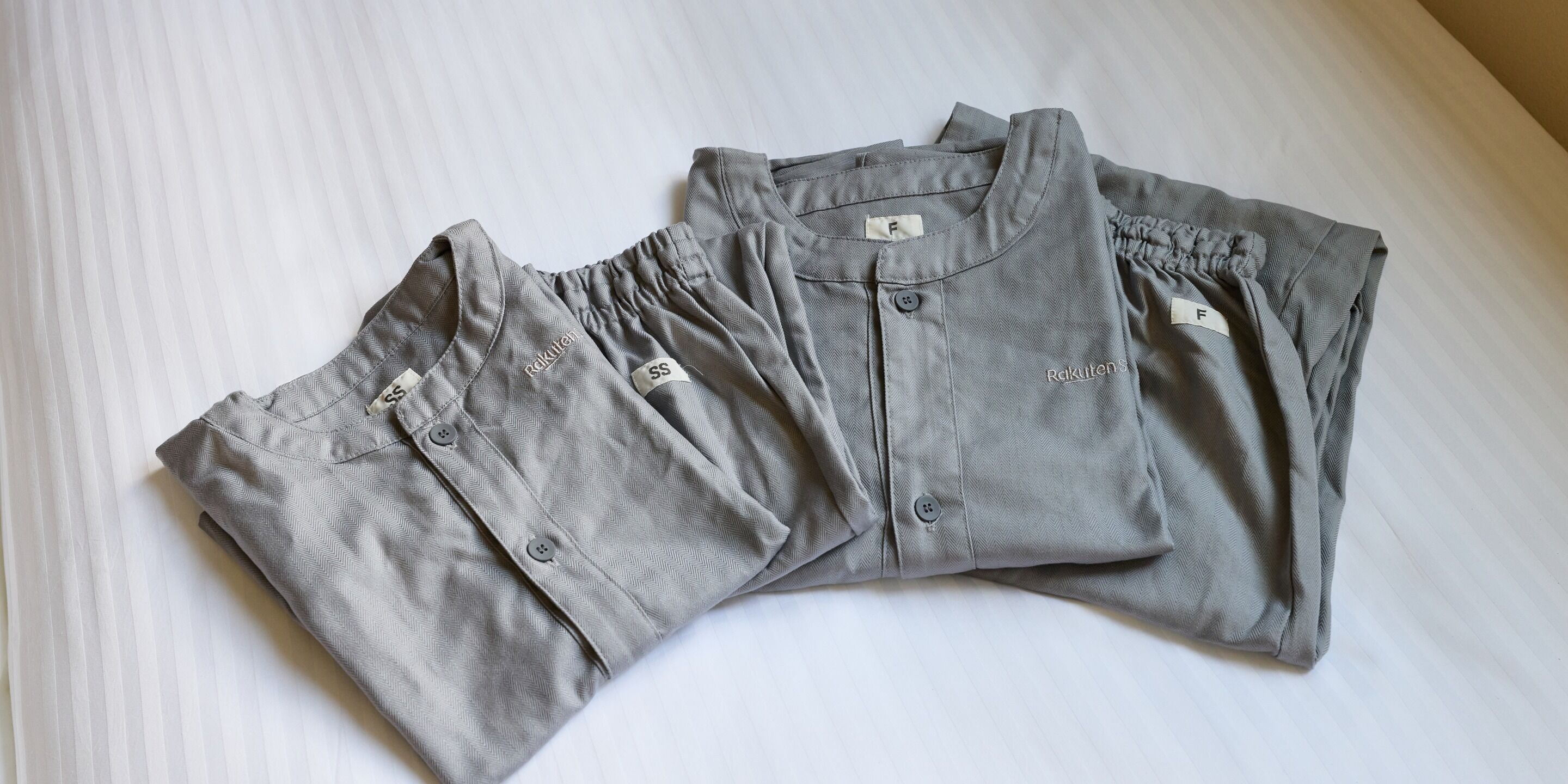 A neatly folded grey shirt with a button-down collar and a tag on the inside.