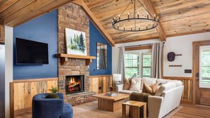 Ein Wohnzimmer mit Kamin, Fernseher und Sofa.
