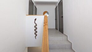 Un escalier avec une rampe en bois et une œuvre d’art accrochée au mur.