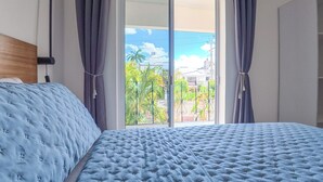 Une chambre à coucher avec un lit, des rideaux, une fenêtre et une vue sur l’extérieur.