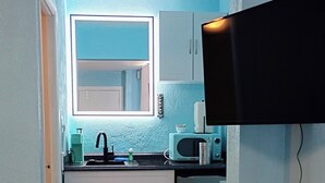 Una cocina compacta con fregadero, microondas y armarios.