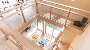 Un intérieur spacieux avec un plafond haut, un plancher en bois et un espace central ouvert aménagé avec des sièges.