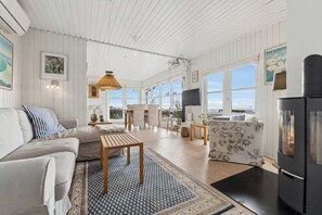 Un salón amplio con sofá, sillones, una mesa de centro y chimenea.