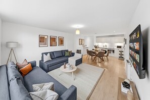 Una sala moderna con sofá, mesa de centro y comedor.