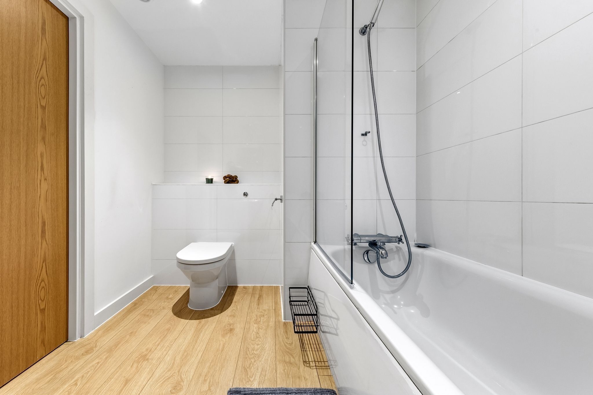 A modern bathroom with a toilet, shower, and bathtub.