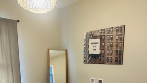 A bedroom with a bed, a wall-mounted mirror, a ceiling light fixture, and a framed quote on the wall. - Cozy family friendly Entire Home l, 2BR,  Free Parking, 20min to Minneapolis (Champlin)