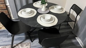 A round table with white plates and a vase of green plants, surrounded by black chairs. - Cozy family friendly Entire Home l, 2BR,  Free Parking, 20min to Minneapolis (Champlin)
